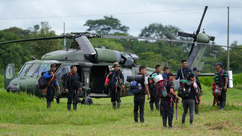 Hombres indígenas esperan para abordar un helicóptero en una base militar en Calamar,...