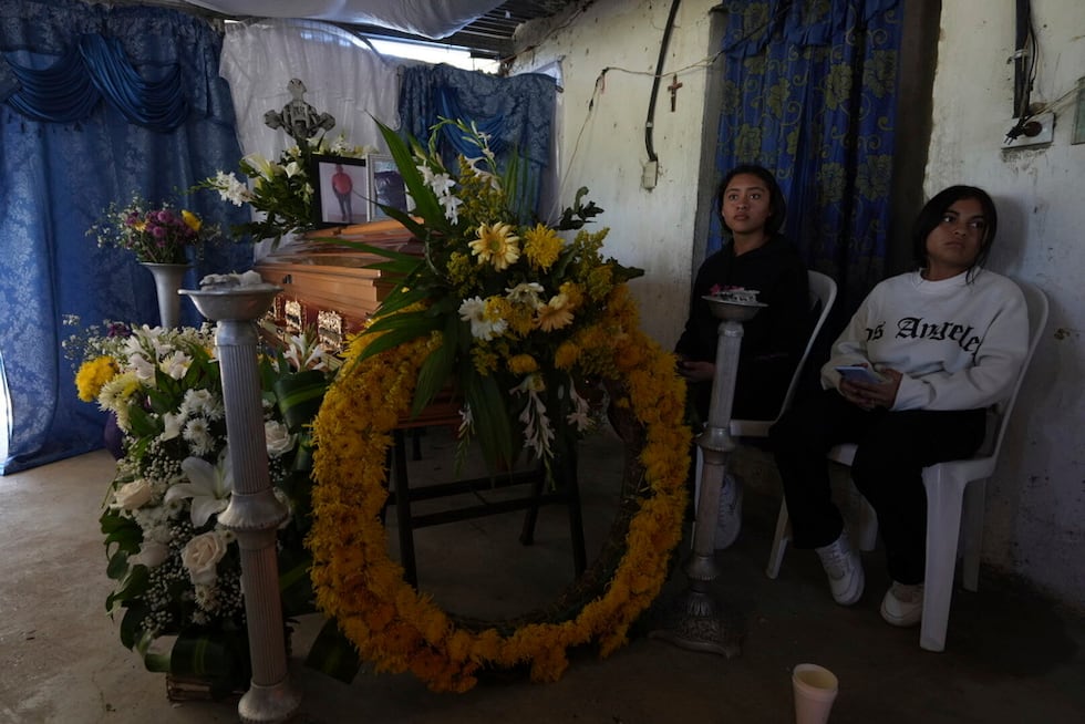 Mujeres se sientan junto a los restos de Emiliano Pérez Cante, quien murió en un accidente de...