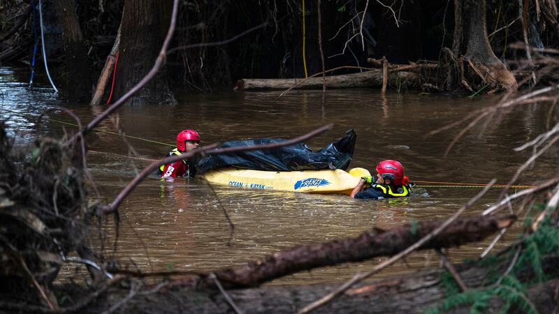 Bomberos de Ciudad Acuña, México, transportan un cuerpo que recuperaron en el río Guadalupe,...
