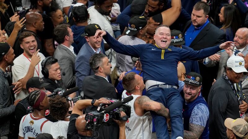 El entrenador de los Nuggets de Denver Michael Malone es alzado tras conquistar el campeonato...