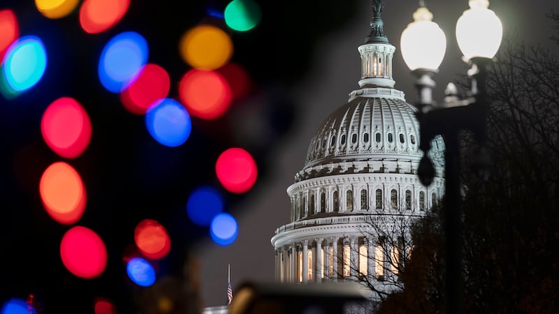 La imagen muestra al Capitolio en Washington con luces navideñas. La Cámara de Representantes...