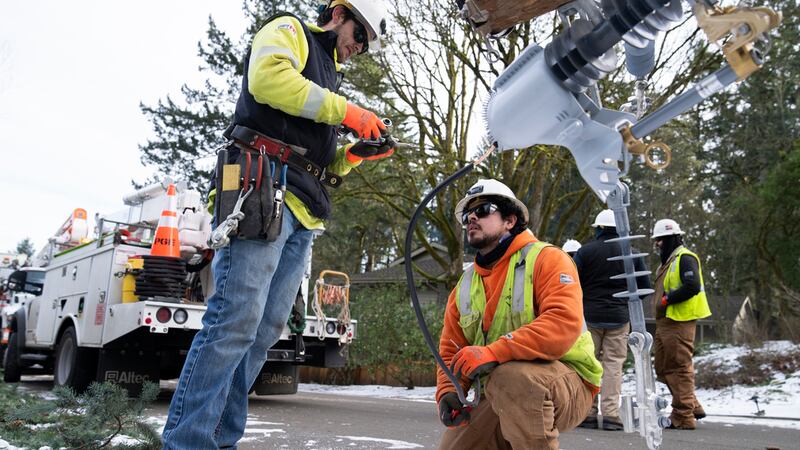 Operarios de PG&E trabajan para restablecer la electricidad en una zona afectada por una...