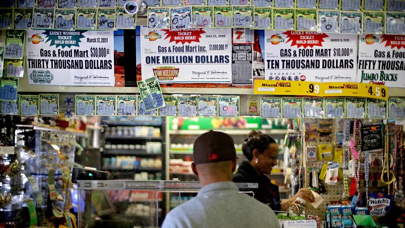 Un cliente espera que se imprima su boleto de lotería en una tienda de conveniencia, el lunes...