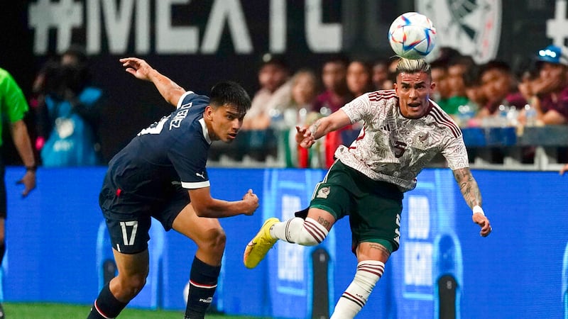 El mexicano Luis Reyes, derecha, disputa el balón con el paraguayo Diego Gómez en partido...