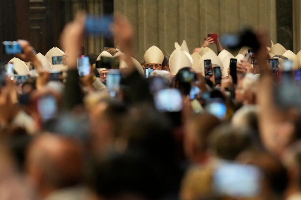 Fieles capturan con sus celulares la imagen de los cardenales que asisten a la última misa...