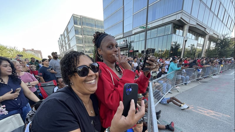 Spectators take a selfie while waiting for the champ to come through during the parade...