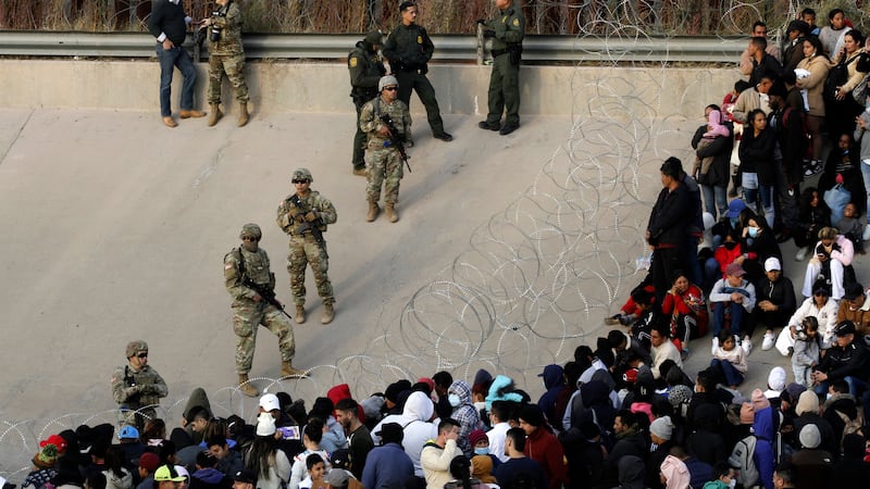 ARCHIVO - Migrantes reunidos en la orilla del río Bravo en la frontera de Estados Unidos con...