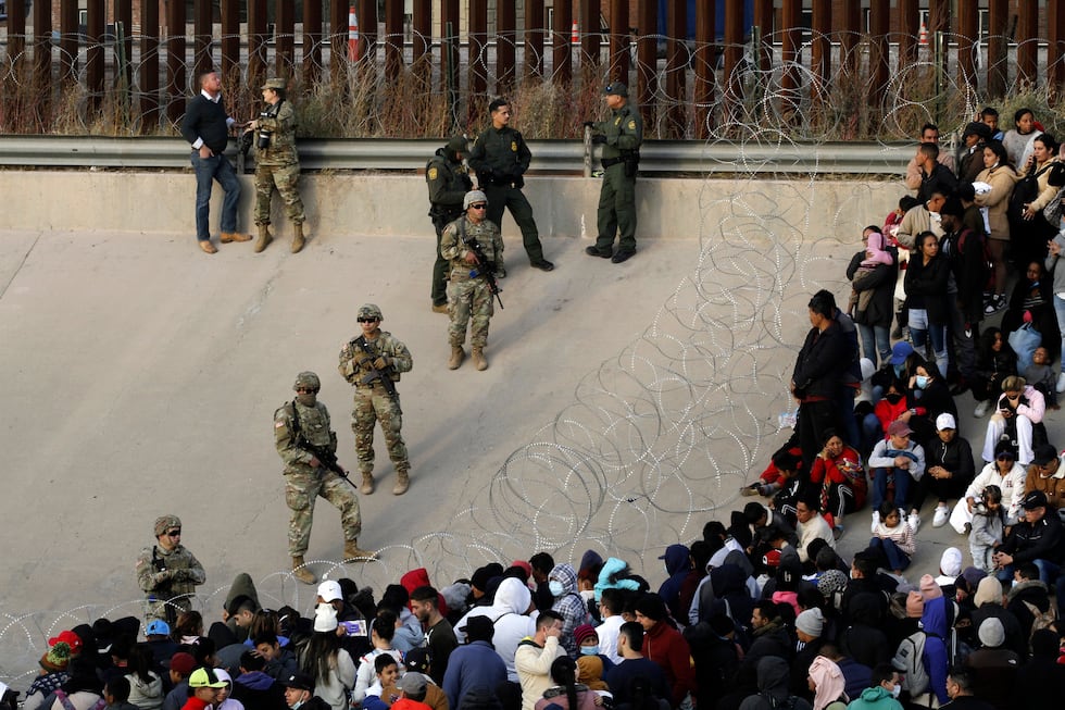 ARCHIVO - Migrantes reunidos en la orilla del río Bravo en la frontera de Estados Unidos con...