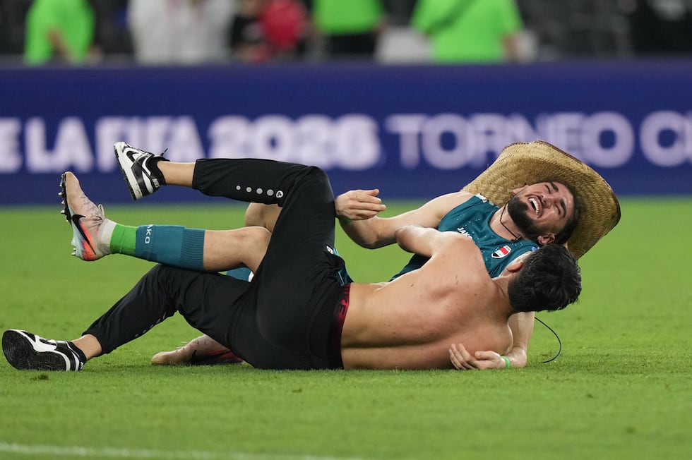 Akram Hashim (arriba) feteja con un aficionado, luego de sellar su pasaje de Irak al Mundial...