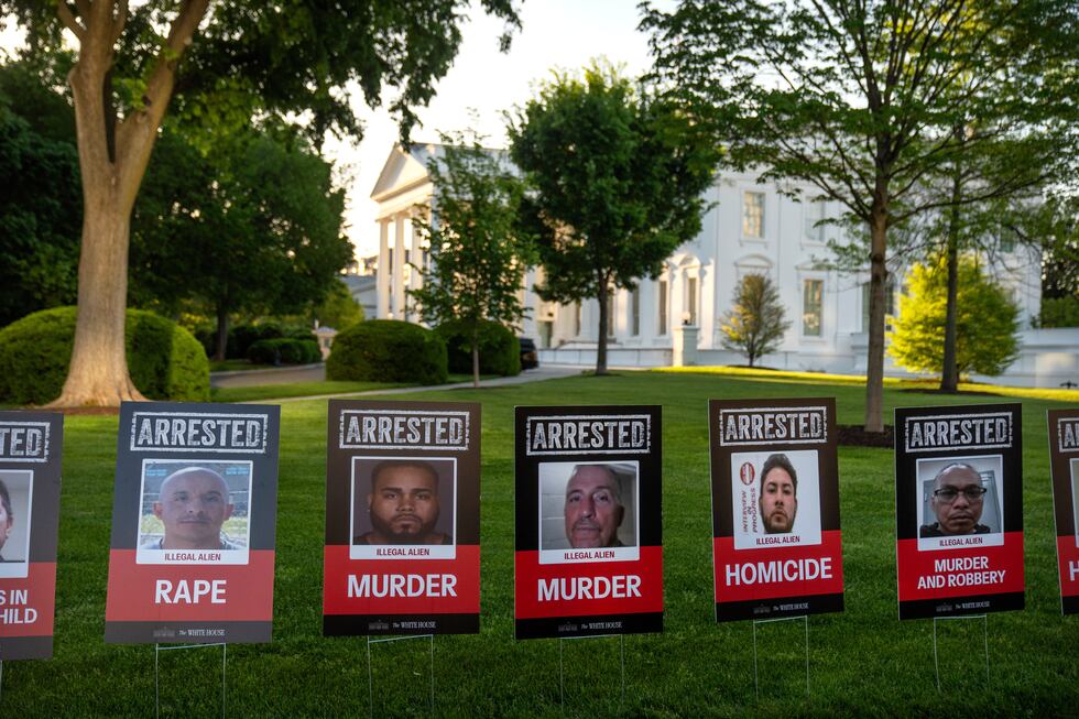 Carteles con fotos de inmigrantes arrestados se alinean en la entrada de la Casa Blanca antes...
