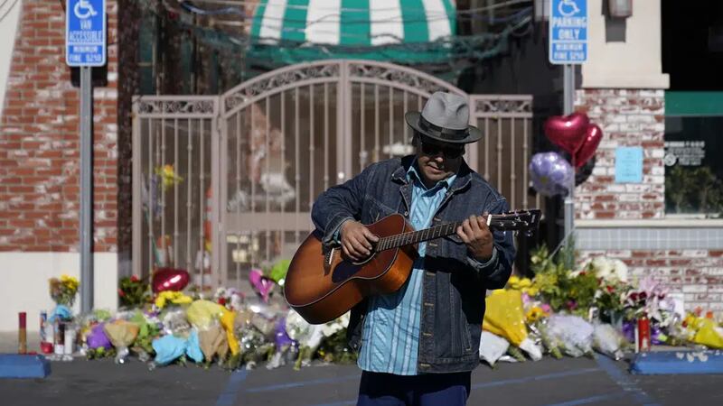 Gabriel Alexander toca la guitarra y canta frente a una ofrenda improvisada afuera del Star...