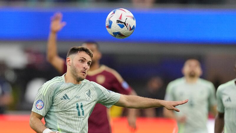 El atacante mexicano Santiago Giménez avista la pelota durante el partido contra Venezuela por...
