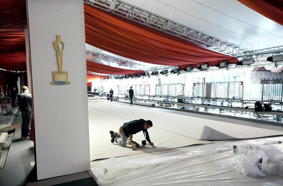 Un trabajador engrapa una alfombra durante los preparativos para la 95a edición de los Premios...