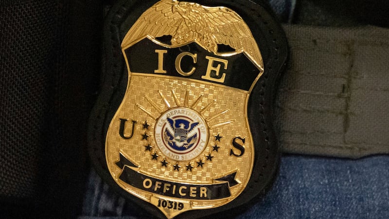 FILE - A federal agent wears an Immigration and Customs Enforcement badge in New York, June...