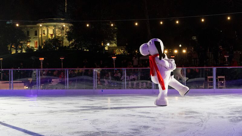 Con la Casa Blanca decorada para las festividades navideñas al fondo, Snoopy patina sobre la...