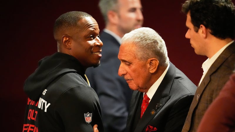 Arthur Blank, derecha, propietario de los Falcons de Atlanta, abraza al coach Raheem Morris...