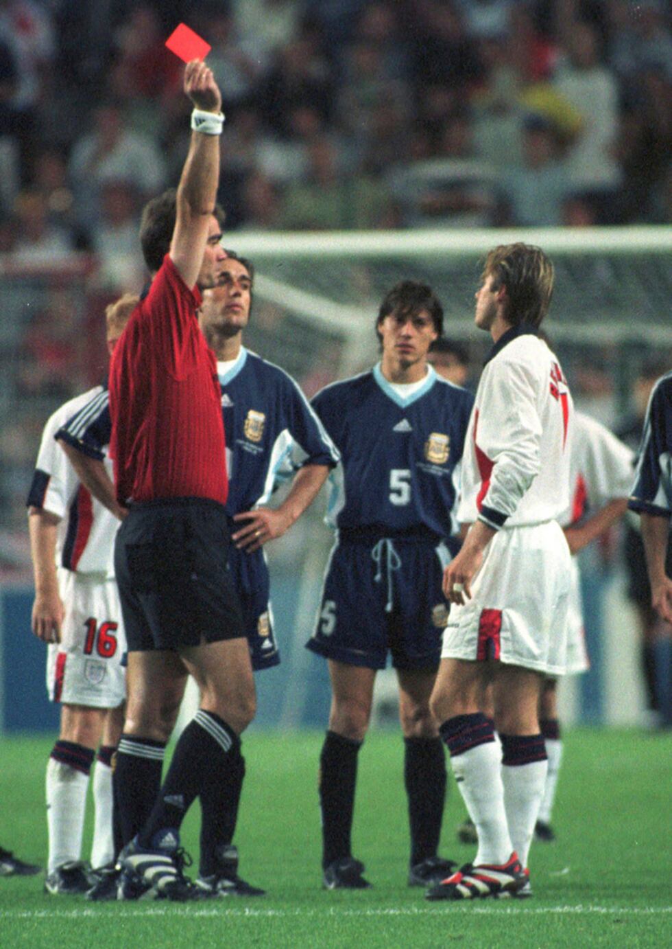 ARCHIVO - El jugador inglés David Beckham recibe una tarjeta roja del árbitro danés Kim Milton...