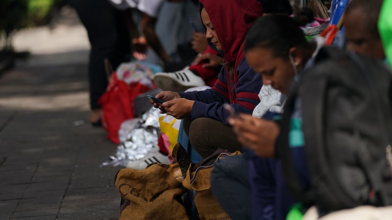 Migrantes venezolanos esperan recibir ayuda en el exterior de la Comisión Mexicana de Ayuda a...