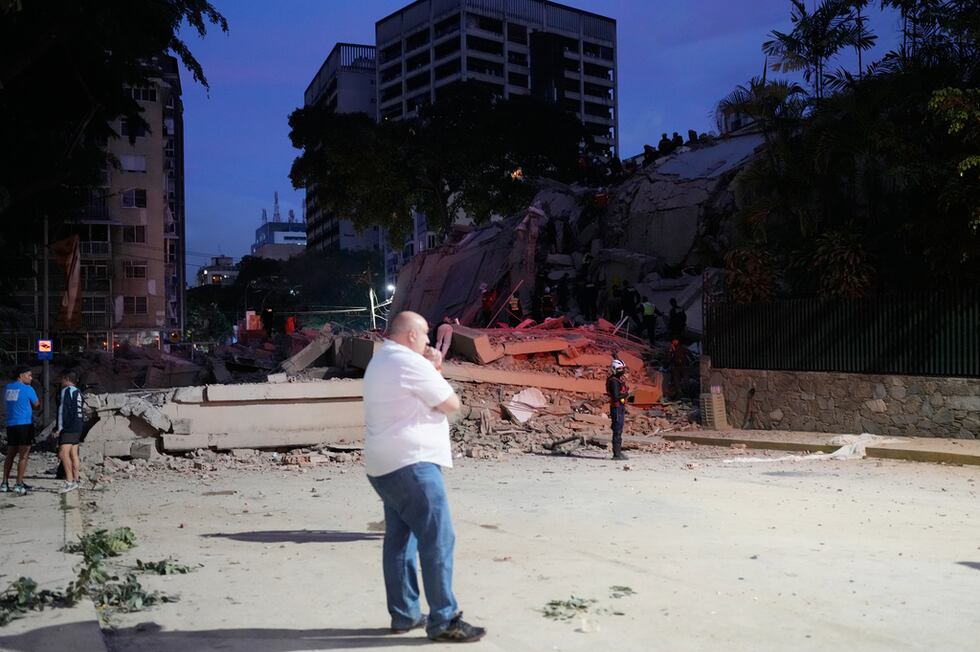 Un hombre permanece de pie junto a un edificio derrumbado tras un terremoto en Caracas,...