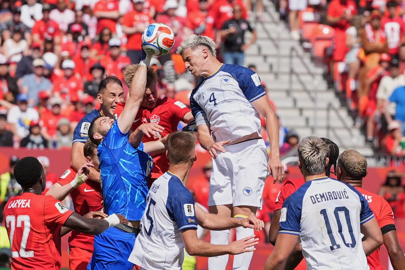 Canada goalkeeper Maxime Crepeau punches the ball clear as Bosnia's Tarik Muharemovic attempts...