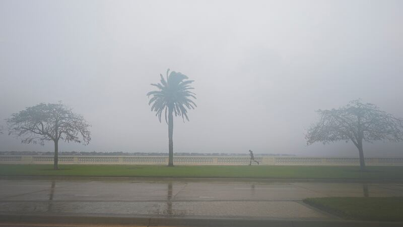 Una persona corre mientras llueve ligeramente previo a la llegada del huracán Milton, el...