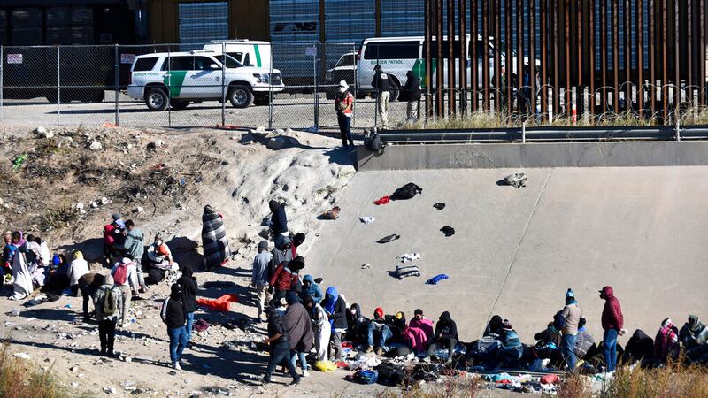 Migrantes esperan a cruzar la frontera entre Estados Unidos y México, el miércoles 14 de...