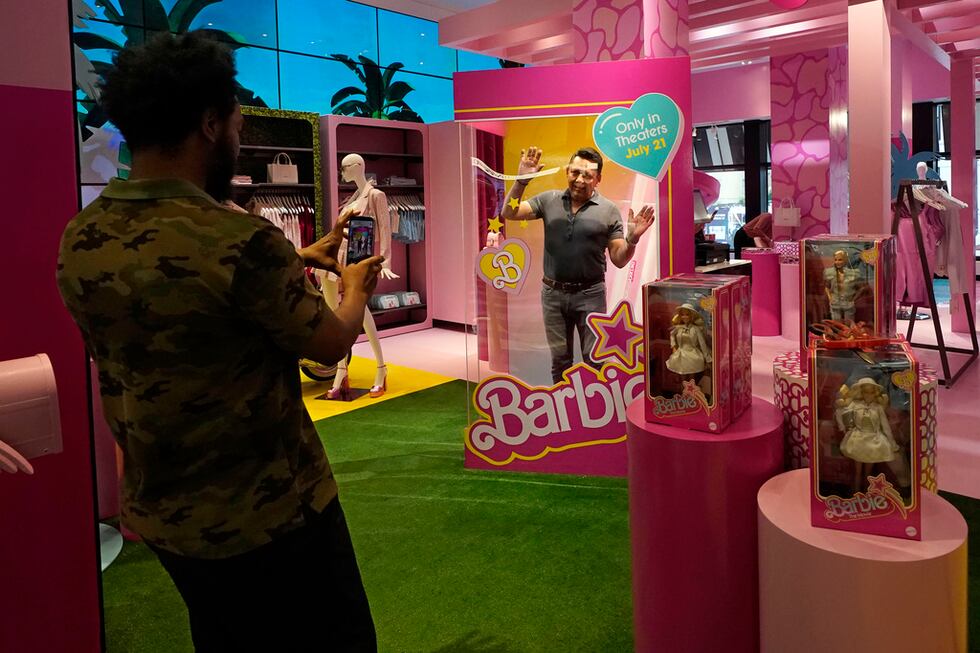 Un hombre posa dentro de una caja de muñeca Barbie en una sección especial con temática de...
