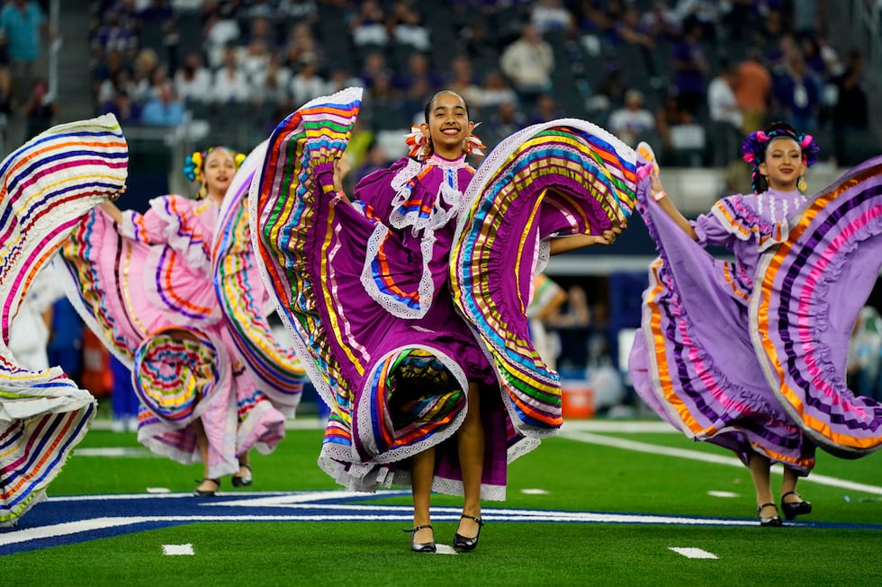 Un grupo de baile folclórico se presenta en el medio tiempo de un partido de la NFL entre los...