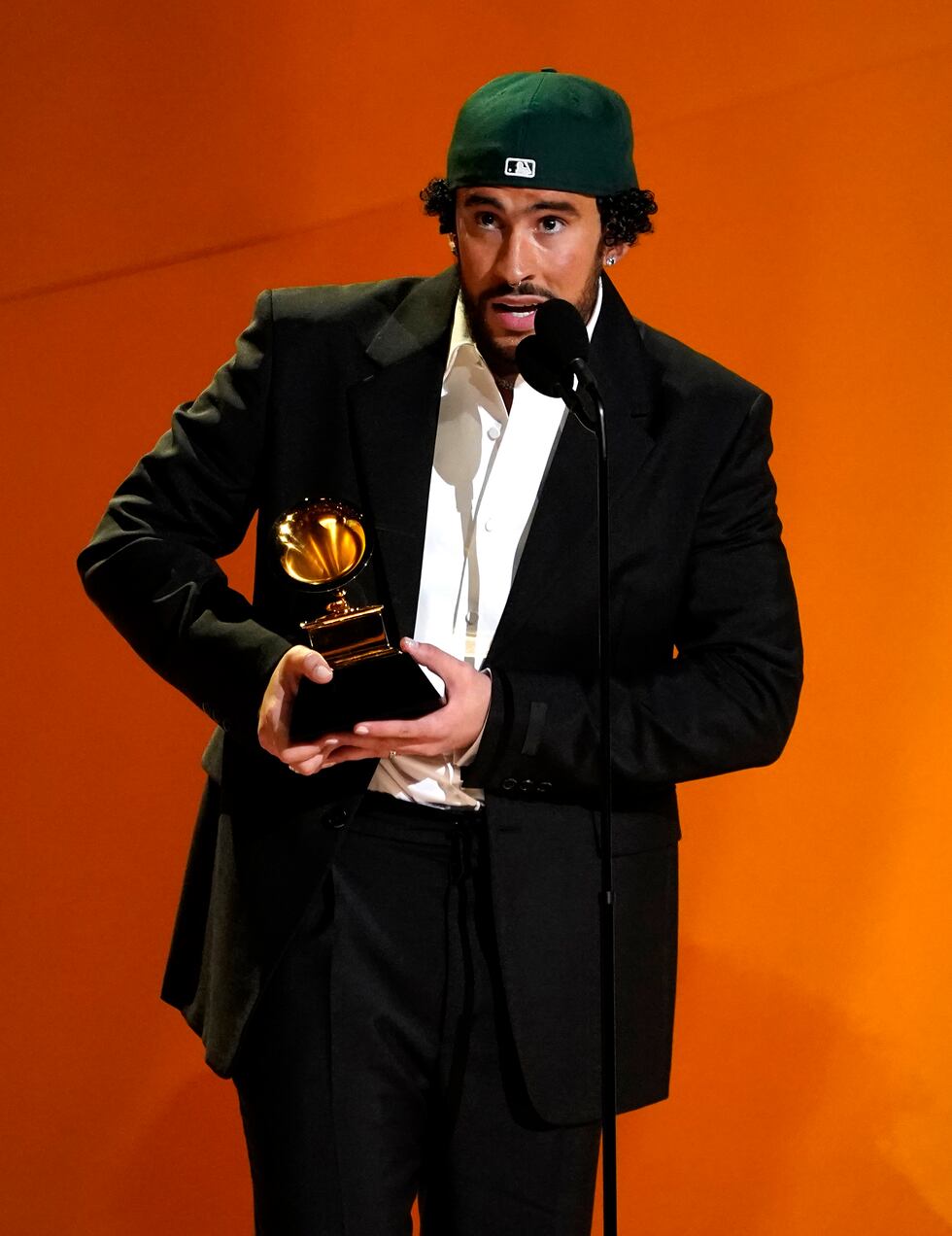 Bad Bunny, izquierda, recibe el premio a mejor álbum de música urbana  por "Un verano sin ti"...