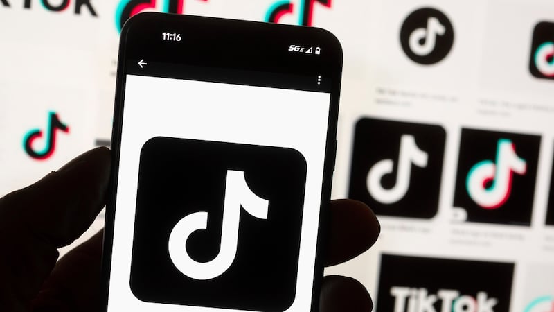 ARCHIVO - El logo de TikTok, visto en la pantalla de un celular, situado delante de la...