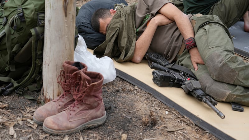 Un soldado israelí descansa cerca de la frontera entre Israel y la Franja de Gaza, el sábado...