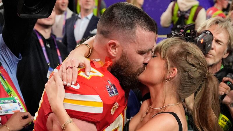 ARCHIVO - El ala cerrada de los Kansas City Chiefs, Travis Kelce (87), besa a Taylor Swift...