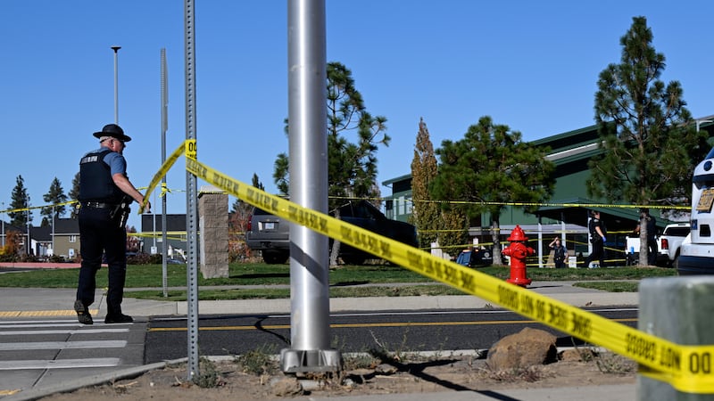 Un agente coloca cinta policial frente a la escuela primaria Silver Rail, donde ocurrió un...