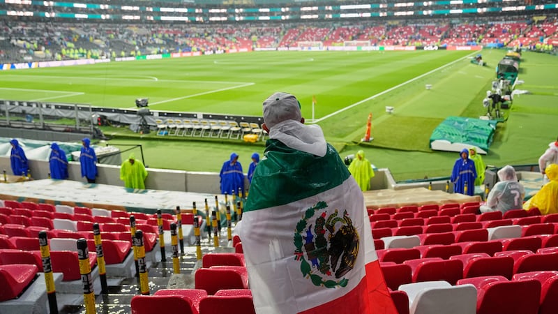 Un aficionado espera bajo la lluvia el inicio del partido entre México y Ecuador en los 18vos...