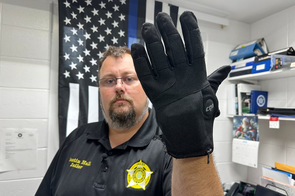 Justin Hall, custodio de la cárcel del condado de Nelson, en Kentucky, muestra un guante de...