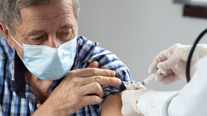 FILE - Elderly man getting a COVID-19 vaccine.