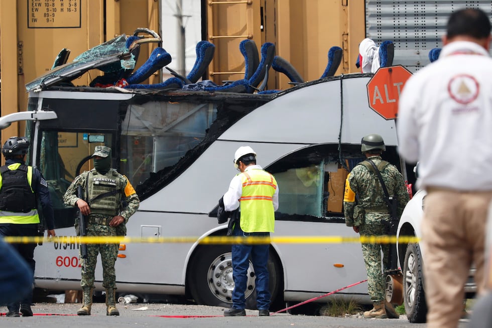 Soldados y personal de rescate trabajan en la escena de un accidente mortal donde un tren...