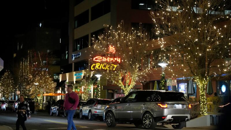 Dos personas cruzan una avenida en el distrito comercial Cherry Creek North el viernes 15 de...