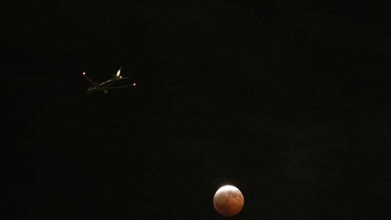Un avión pasa junto a la Luna durante un eclipse lunar parcial, en Los Ángeles, el 27 de...