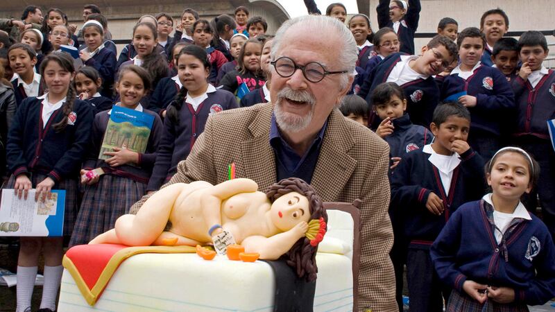 ARCHIVO - El artista colombiano Fernando Botero se ríe junto a un pastel decorado a semejanza...