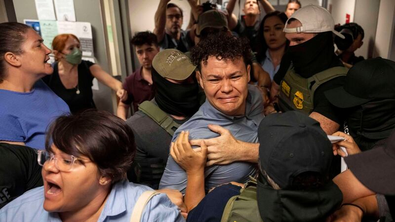 Agentes federales detienen a Carlos Javier Lopez Benitez (centro), quien es oriundo de...