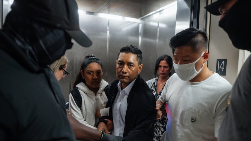ARCHIVO - Agentes federales de Inmigración y Aduanas sacan a un hombre de un ascensor cuando...