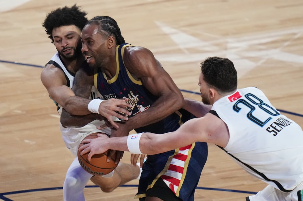 Kawhi Leonard, centro, del equipo de las "Barras" dribla entre el base canadiense Jamal...