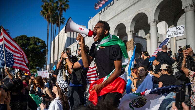 Un hombre grita a través de un megáfono fuera del Ayuntamiento de la ciudad durante las...