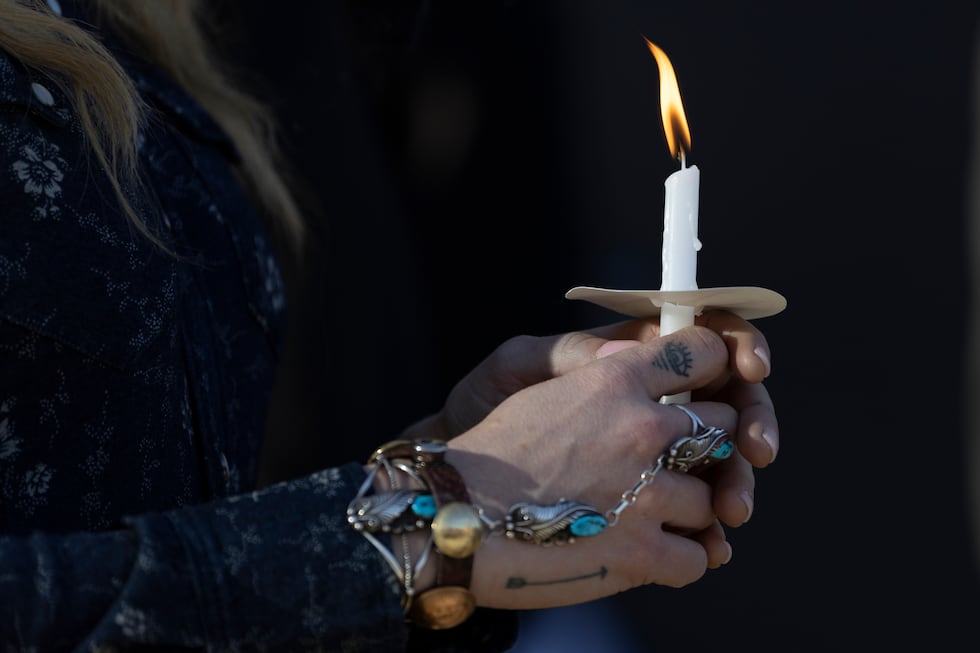 Una mujer sostiene una vela durante una vigilia en honor a las víctimas de la masacre en la...