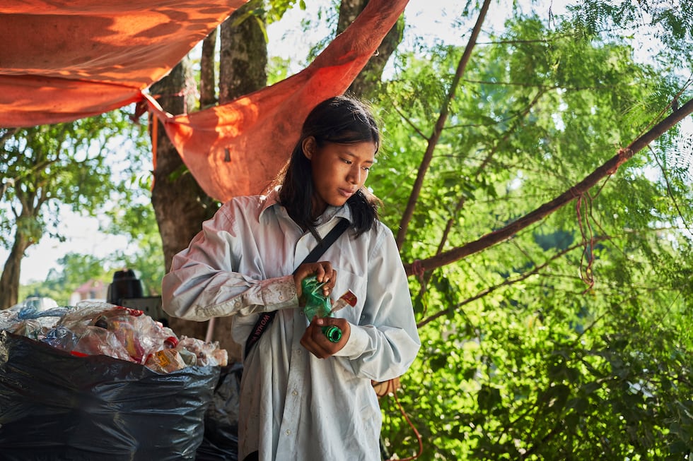 Isela Santiago Morales, que trabaja con su familia recogiendo botellas PET, clasifica residuos...