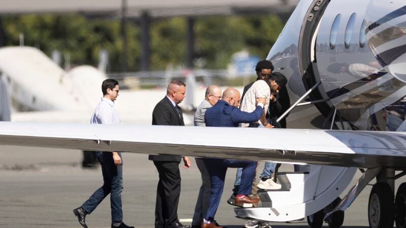 Harjinder Singh es escoltado hacia un avión por el vicegobernador de Florida, Jay Collins, y...