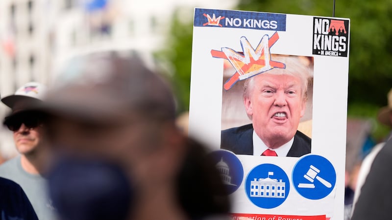 A demonstrator holds a sign during a "No Kings" protest, Saturday, June 14, 2025, in Atlanta....