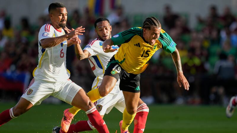 El jamaiquino Joel Latibeaudiere (derecha) es derribado por el venezolano Yangel Herrera...