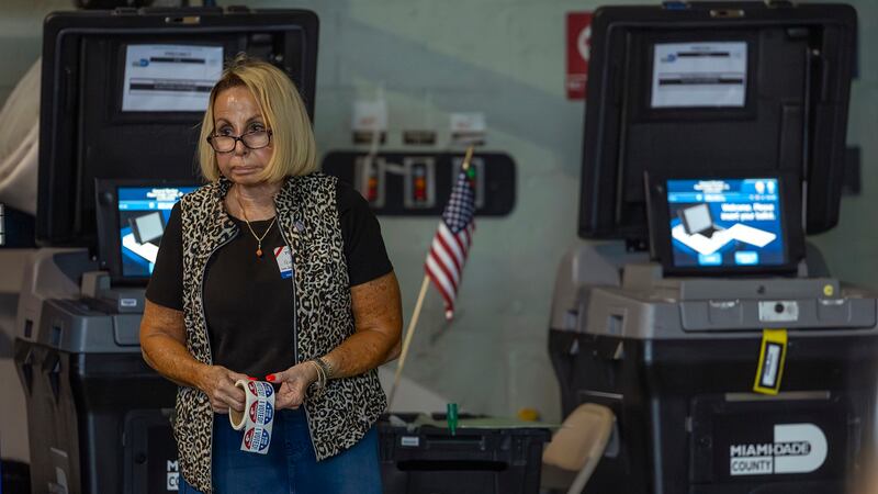 Una trabajadora electoral sostiene un rollo de adhesivos que dicen “¡Yo vote!” el día de la...